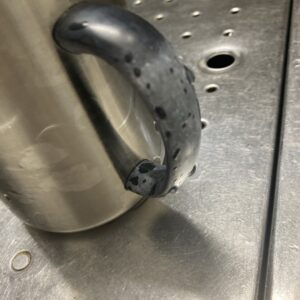 ステンレスのマグカップを酸素系漂白剤を溶いた熱湯につけ置き洗いしたら、持ち手の部分が変色してしまった写真。